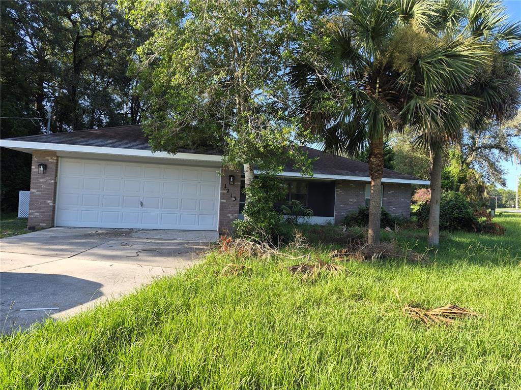 A single-story brick house with a two-car garage and a large front yard — 1213 W SORRENTO DRIVE, CITRUS SPRINGS, FL
