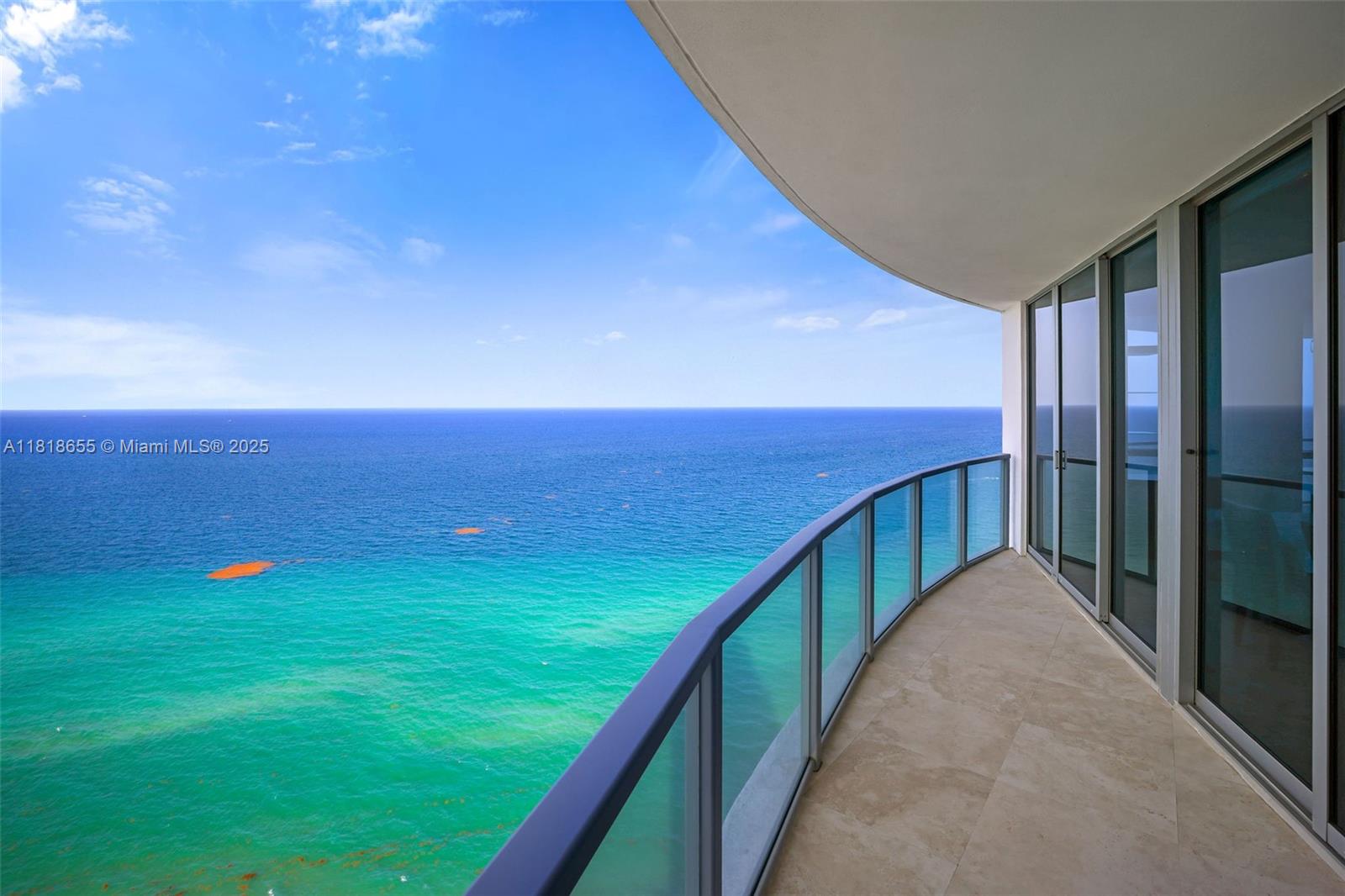 A curved balcony with glass railings overlooks the ocean under a clear blue sky — 3101 S Ocean Dr # 2708, Hollywood FL 33019, HOLLYWOOD, FL