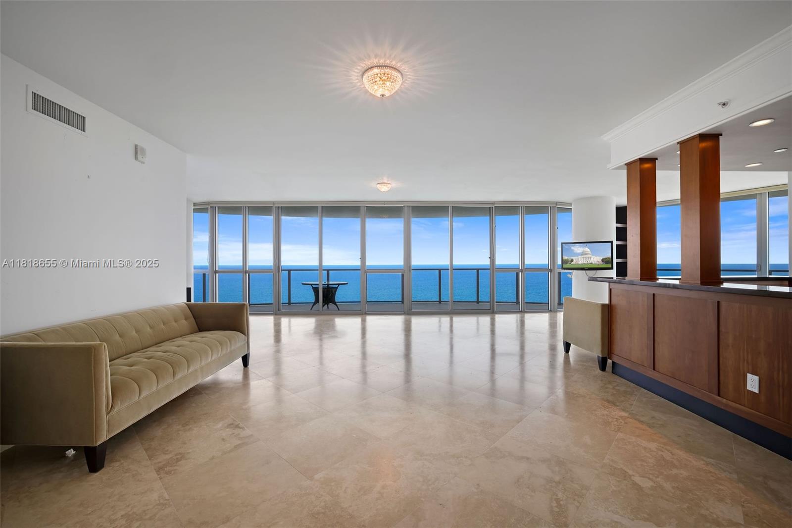A spacious living room features a beige sofa, tile flooring, and floor-to-ceiling ocean views — 3101 S Ocean Dr # 2708, Hollywood FL 33019, HOLLYWOOD, FL
