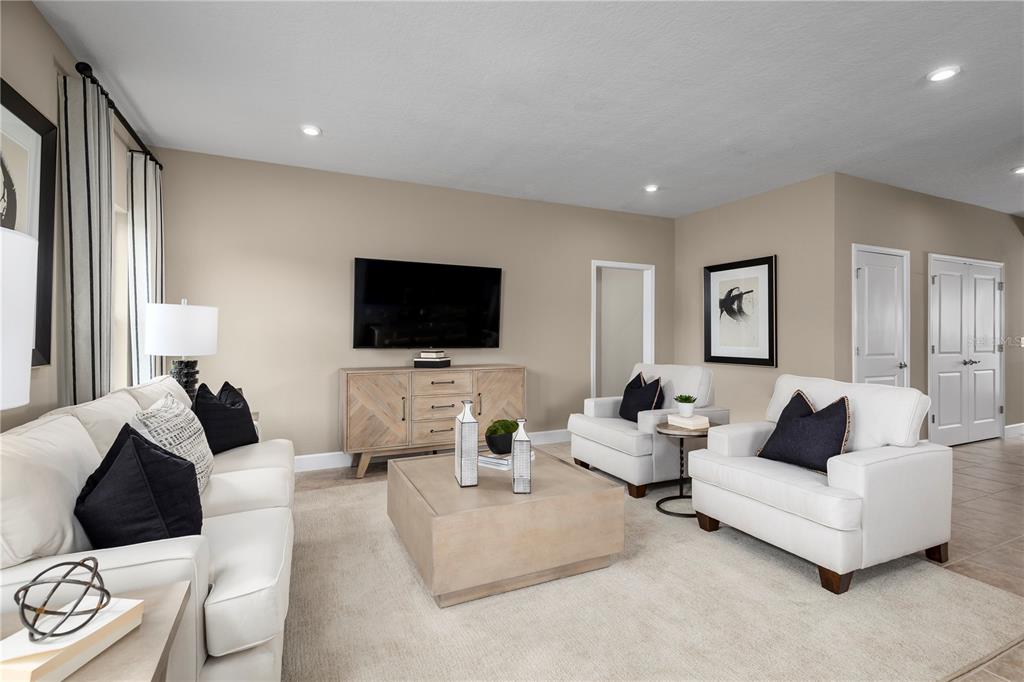 A living room features white sofas and armchairs, a wooden media console, and a square table — 378 HAMMOCK OAKS BOULEVARD, LADY LAKE, FL