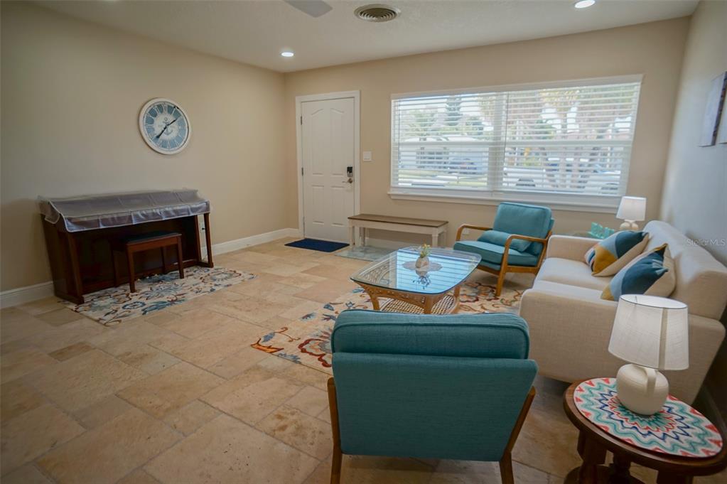 A living room features tile flooring, a piano, two teal armchairs, and a white sofa — 929 LANTANA AVENUE, CLEARWATER BEACH, FL