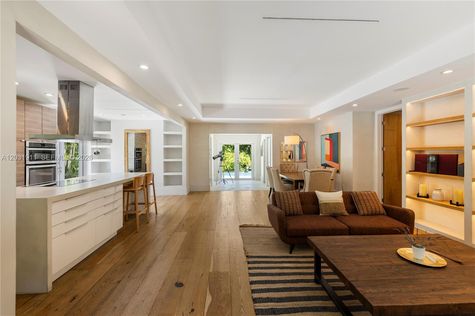 An open-concept living area features a modern kitchen, dining space, and hardwood flooring — 651 NE 52nd Ter, Miami FL 33137, MIAMI, FL
