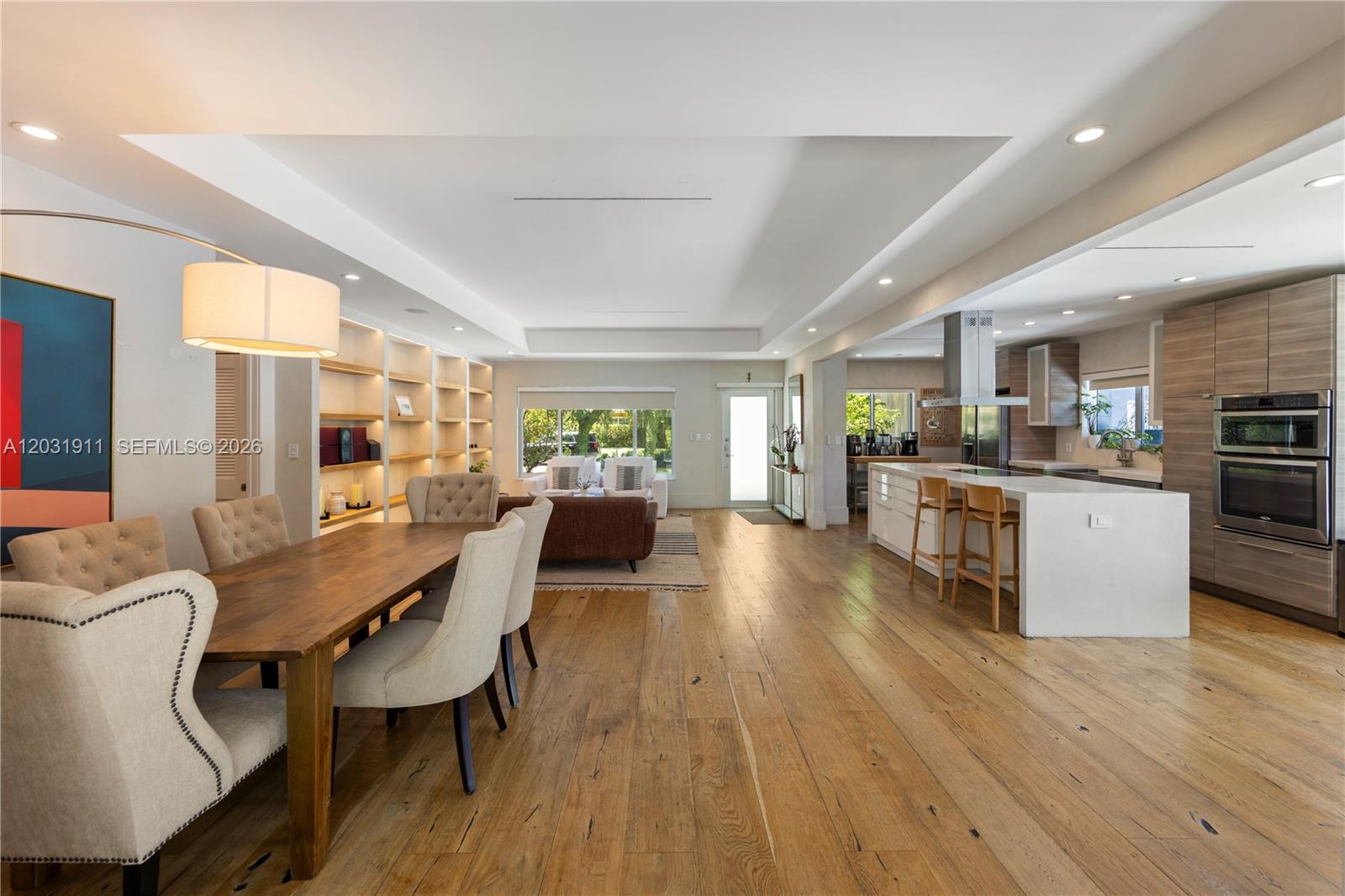 An open-concept living area features a dining space, kitchen with island, and hardwood flooring — 651 NE 52nd Ter, Miami FL 33137, MIAMI, FL