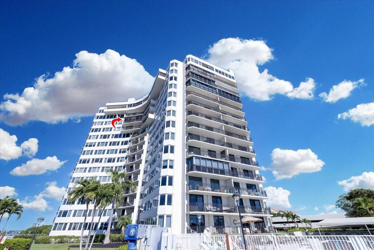 A low-angle exterior view of a tall white residential building under a blue sky — 3912 S Ocean Boulevard # 1211, Highland Beach FL 33487, HIGHLAND BEACH, FL