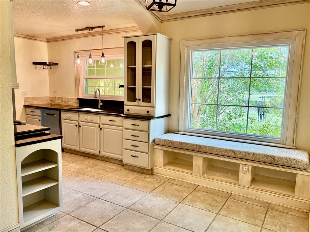 A kitchen with white cabinets, a window seat, and a view of a pond outside — 430 GEHR LANE, LAKE MARY, FL