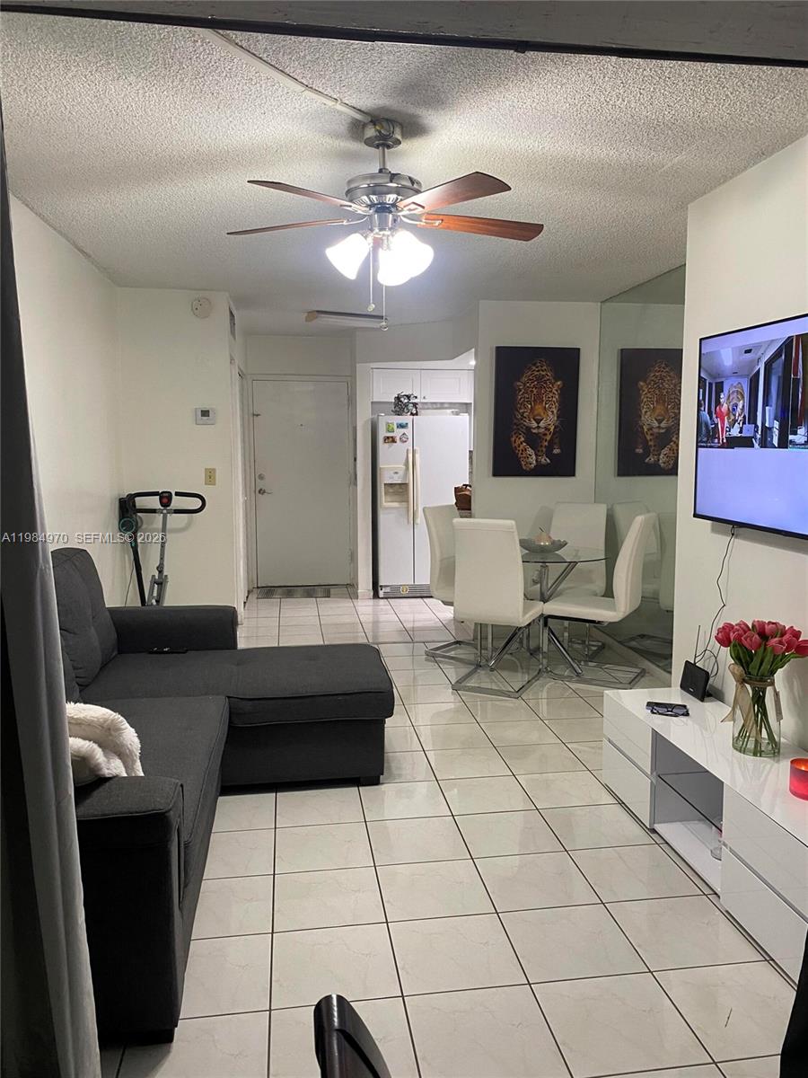 A living room and dining area with tile floors, a sectional sofa, and a television — 9405 W Flagler St # D105, Miami FL 33174, MIAMI, FL