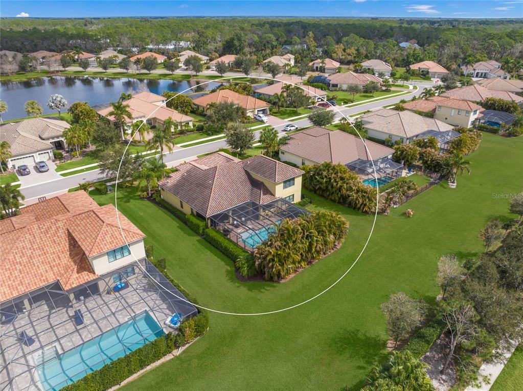 An aerial view shows a single-family home with a screened pool and a tiled roof — 7809 PASSIONFLOWER DRIVE, SARASOTA, FL