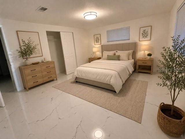 A bedroom features a bed, dresser, nightstands, and a potted plant on tiled floors — 4453 TERRY LOOP, NEW PORT RICHEY, FL
