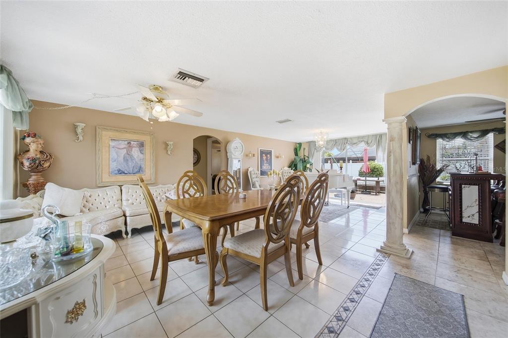 A dining room with a wooden table, chairs, tile floors, and an adjacent bar area — 7140 ROCKWOOD DRIVE, PORT RICHEY, FL