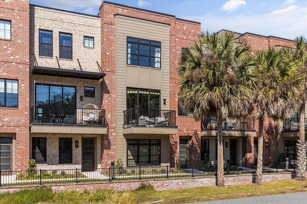 A row of modern brick townhomes features balconies, large windows, and a metal fence — 68 N PARK AVENUE, WINTER GARDEN, FL