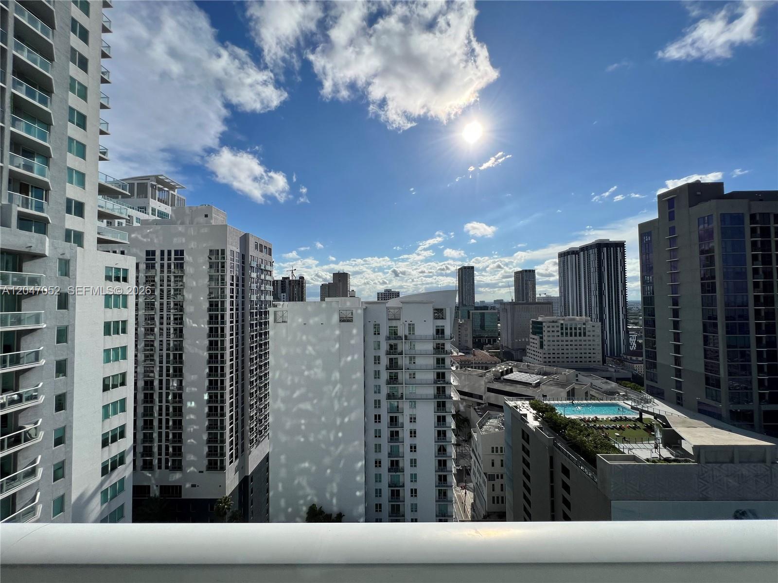 A high-angle view of a city skyline featuring multiple modern apartment buildings under a sunny sky — 244 Biscayne Blvd # 2610, Miami FL 33132, MIAMI, FL