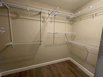 A walk-in closet features white wire shelving, beige walls, and wood-look flooring — 12 BUNKER VIEW PLACE, PALM COAST, FL