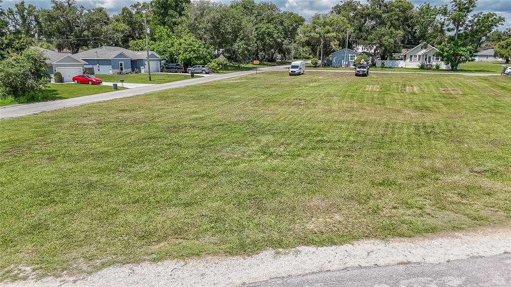 An elevated view of a large, vacant grassy lot bordered by a residential street — US 98, DADE CITY, FL