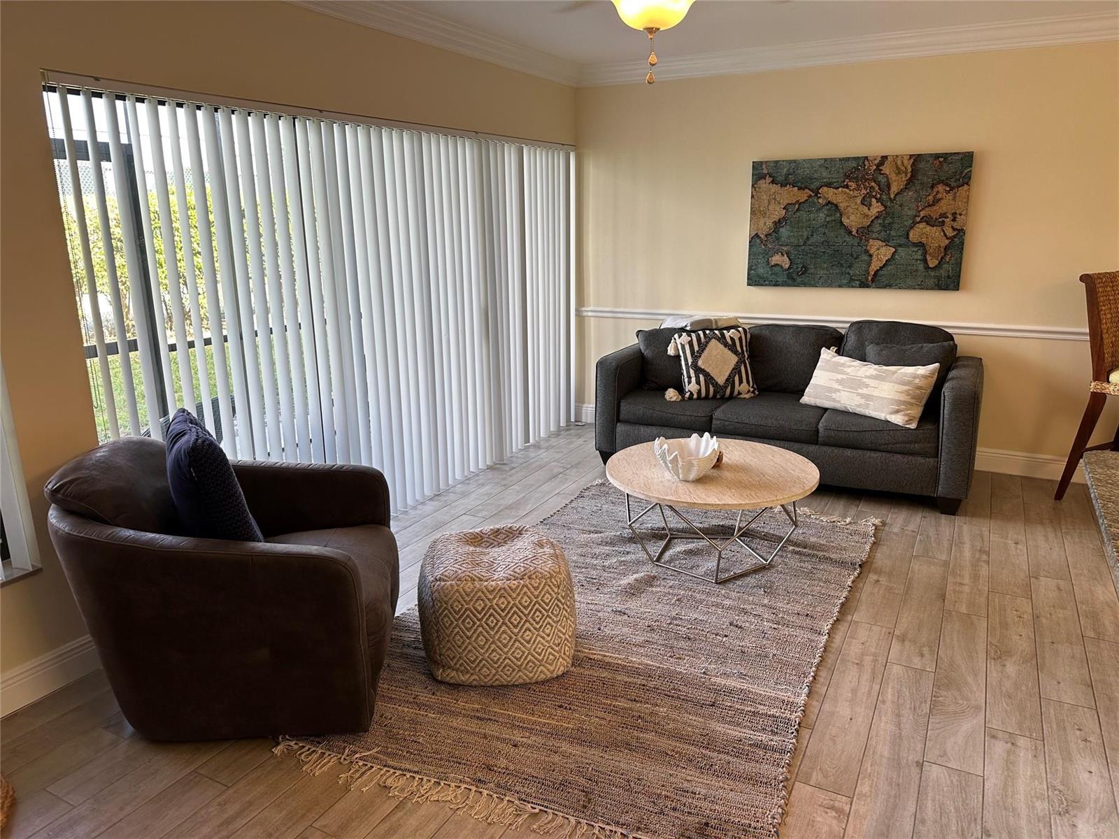 A living room features a dark sofa, a round coffee table, and a brown armchair — 1605 US Highway 1 V-4 # 104, Jupiter FL 33477, JUPITER, FL
