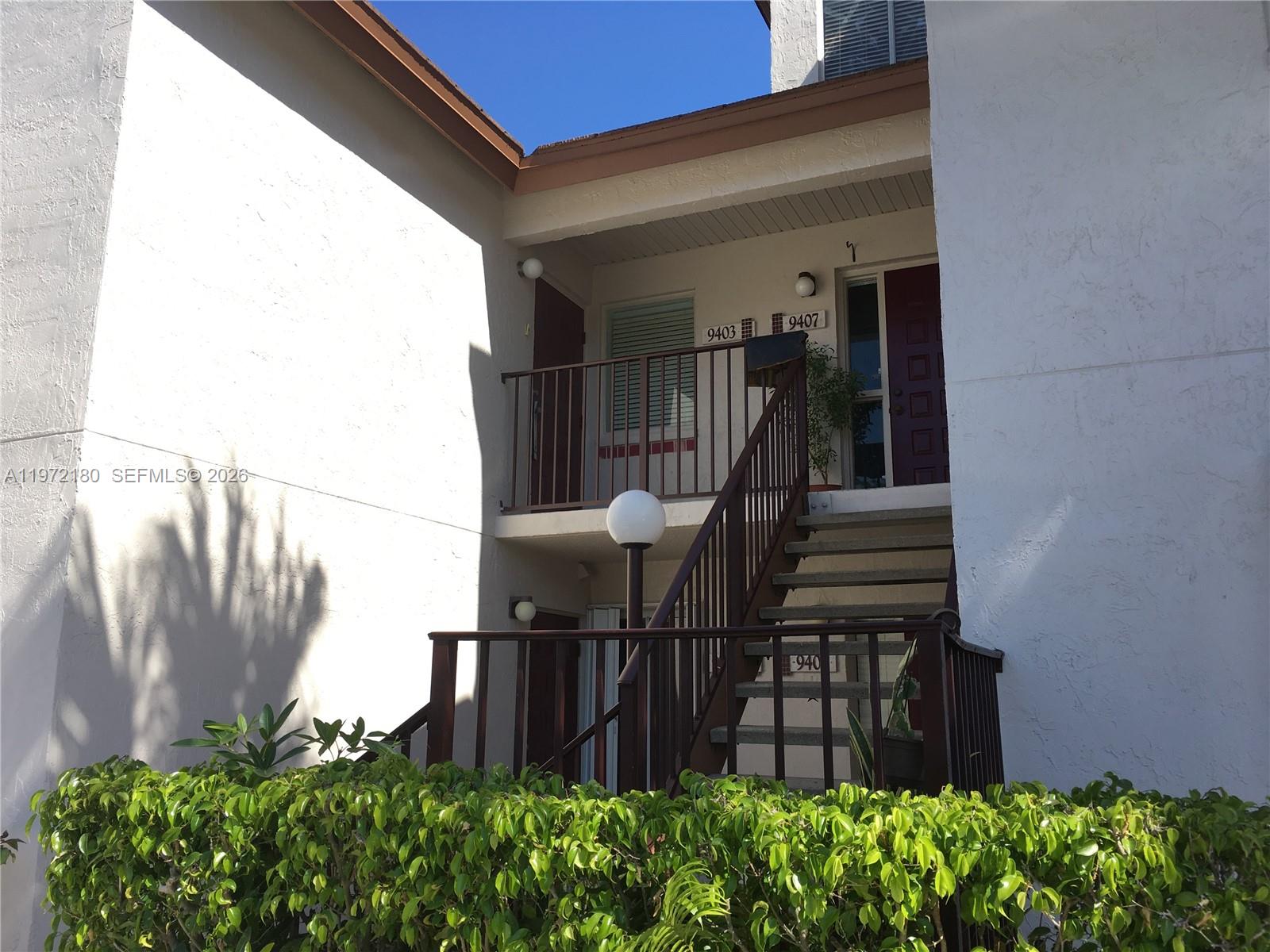 An exterior view shows a two-story building with a staircase leading to upper-level units — 9403 SW 140th Ct # 9403, Miami FL 33186, MIAMI, FL
