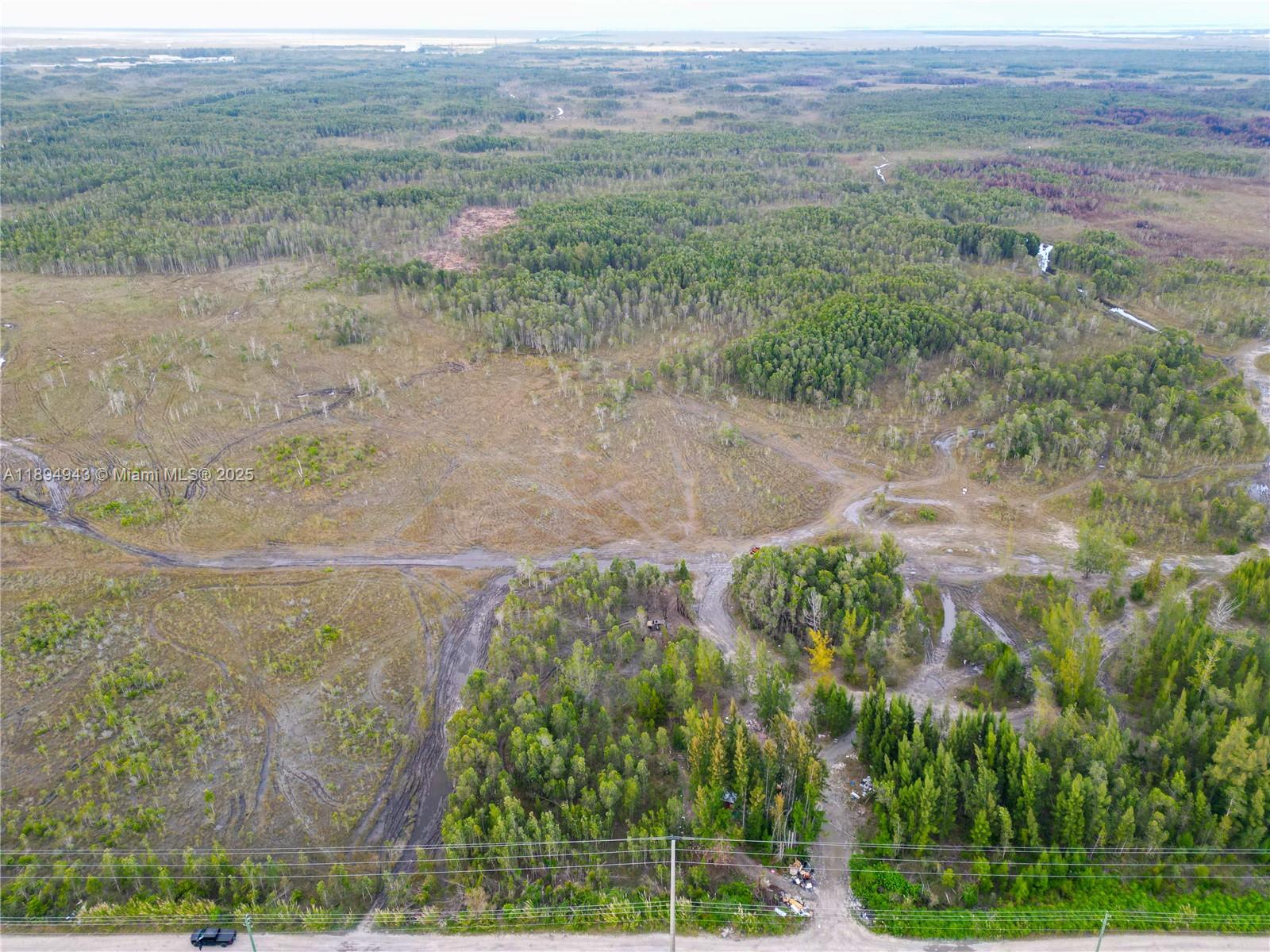 An aerial view shows a large, undeveloped plot of land with trees and dirt paths — 172 Ave SW 38-39 St, Miami FL 33185, MIAMI, FL