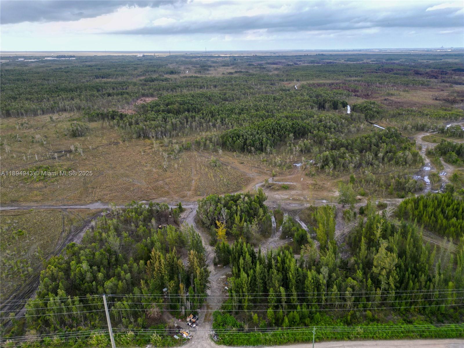 An aerial view shows a large, undeveloped plot of land with trees and dirt paths — 172 Ave SW 38-39 St, Miami FL 33185, MIAMI, FL