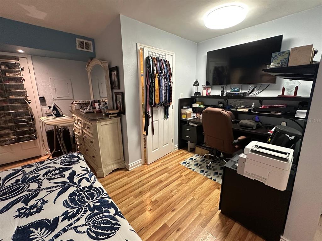 A bedroom features a desk, television, dresser, and a bed with a blue patterned comforter — 4612 MESA VERDE DRIVE, ST CLOUD, FL