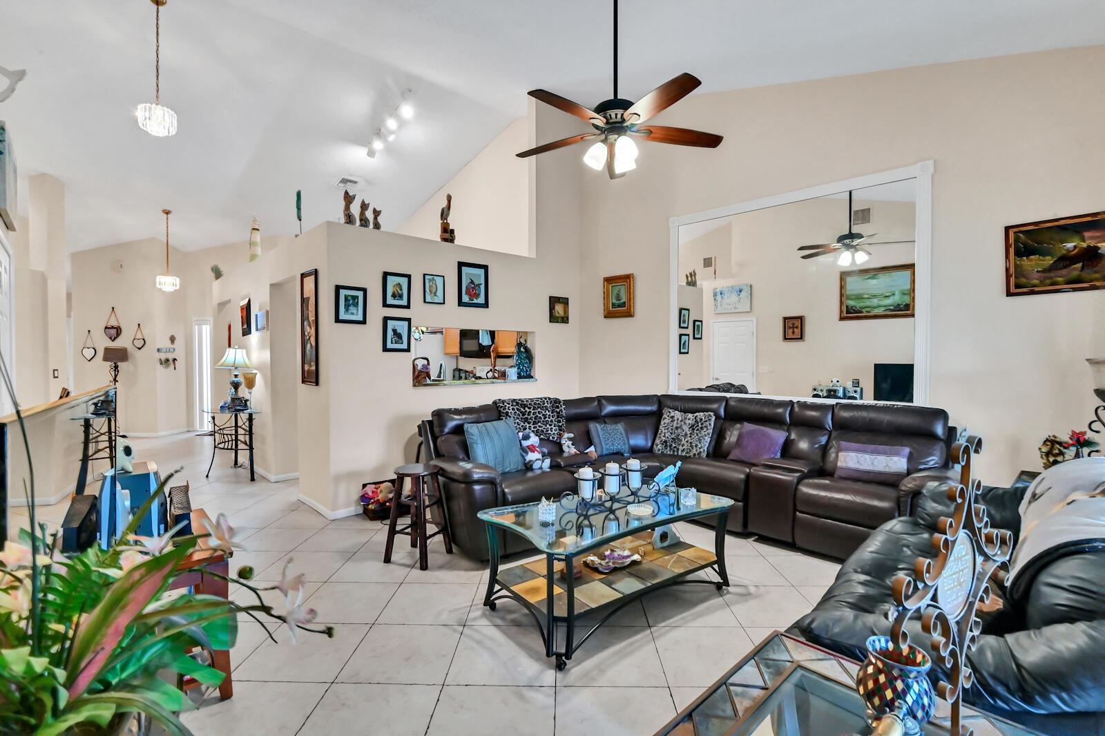A living room features a large brown sectional sofa, a glass coffee table, and vaulted ceilings — 8072 Key West Lane, Boynton Beach FL 33472, BOYNTON BEACH, FL