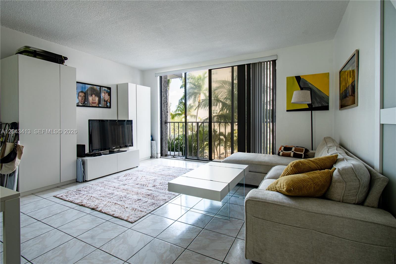 A living room features white tile floors, a sectional sofa, and a sliding glass door — 800 West Ave # 414, Miami Beach FL 33139, MIAMI BEACH, FL