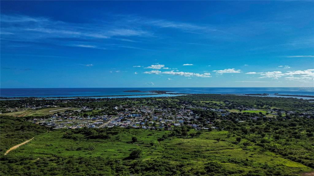 An aerial view of a coastal town surrounded by green fields and the ocean — CARR 3301 KM 1.9 COMBATE UNIT 100, CABO ROJO, PR