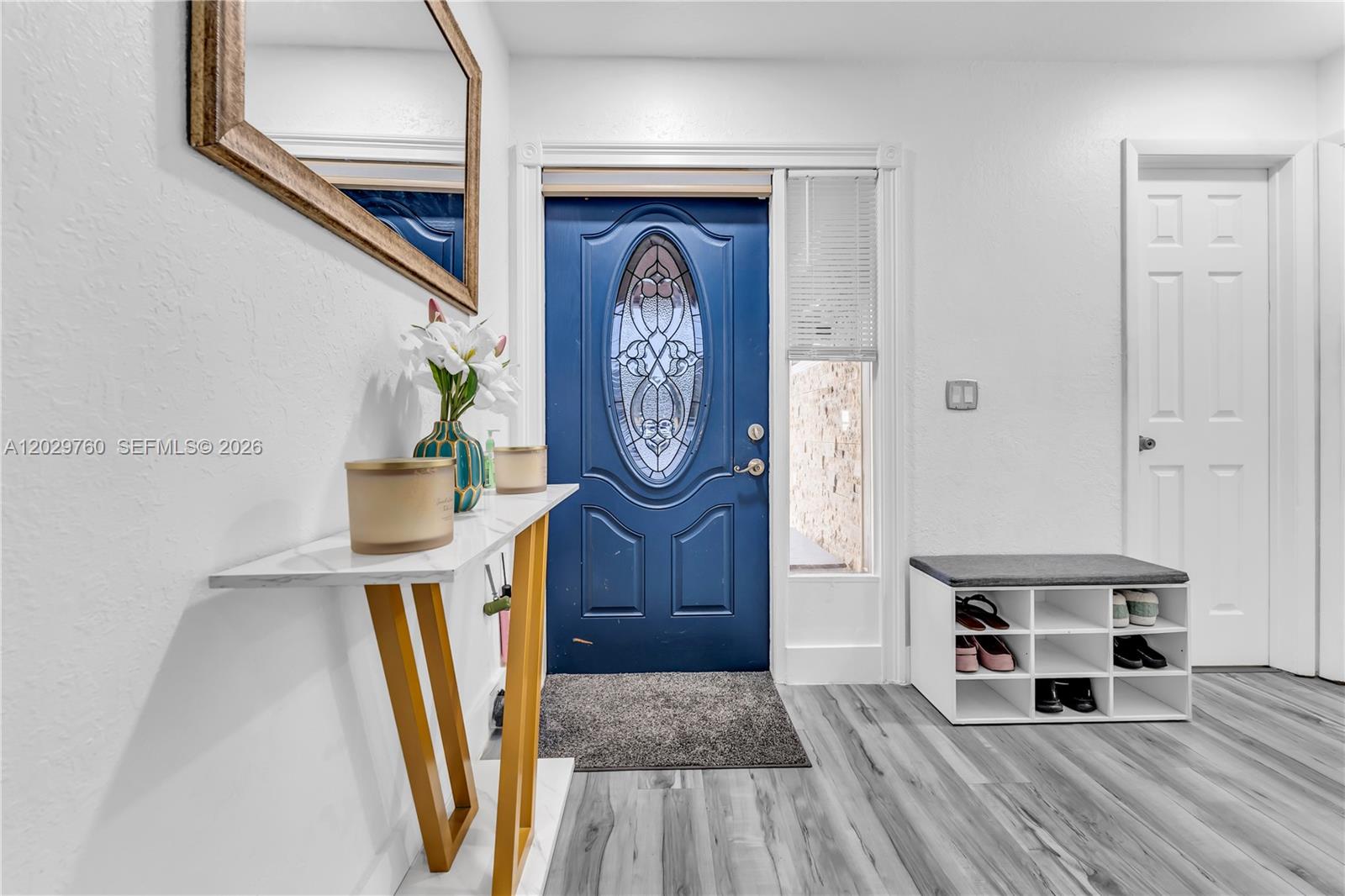 An entryway features a blue front door, a console table, and a shoe storage bench — 1721 SW 87th Ter, Miramar FL 33025, MIRAMAR, FL