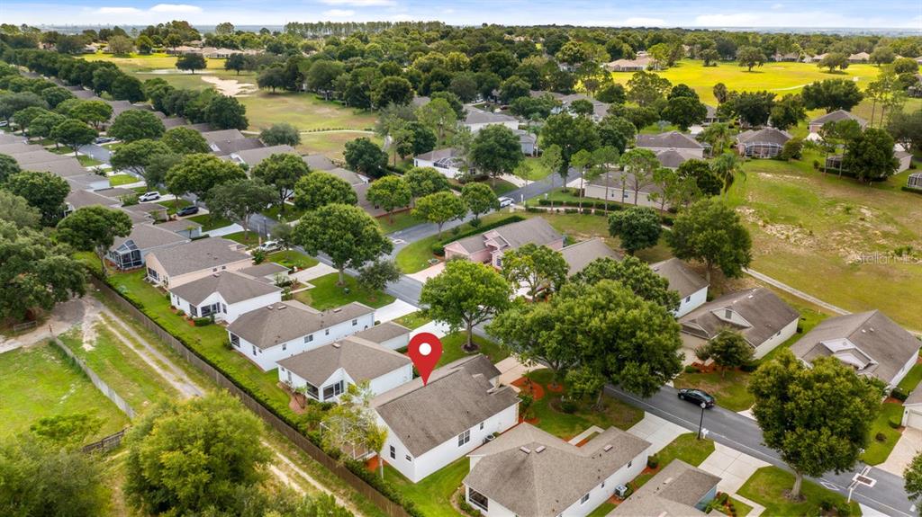An aerial view shows a residential neighborhood with houses, green lawns, and mature trees — 4127 CAPLAND AVENUE, CLERMONT, FL