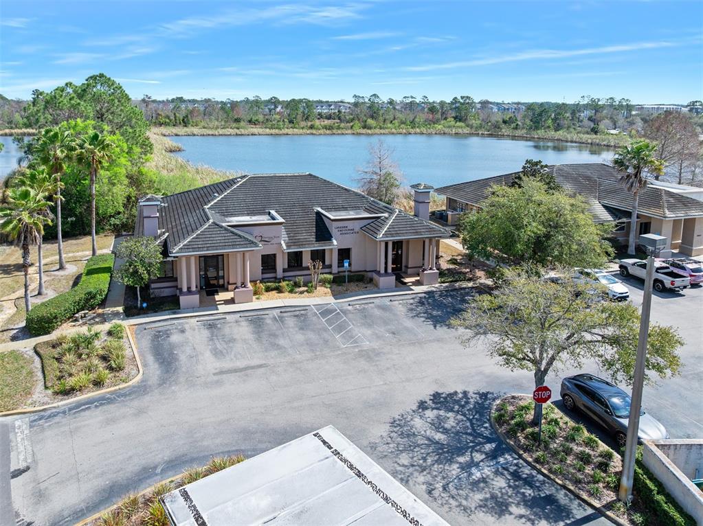 An aerial view shows a commercial building with a parking lot next to a lake — 1667 N CLYDE MORRIS BOULEVARD, DAYTONA BEACH, FL