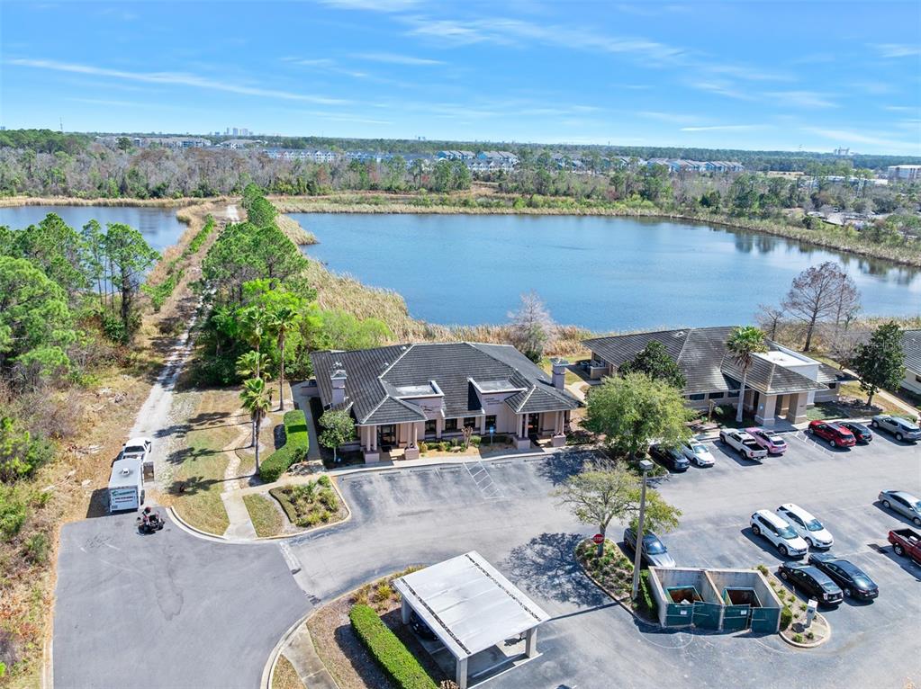 An aerial view shows a commercial building with a parking lot next to a lake — 1667 N CLYDE MORRIS BOULEVARD, DAYTONA BEACH, FL