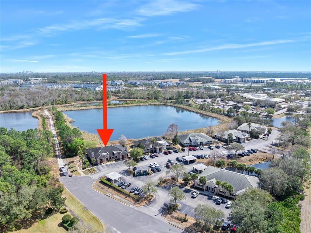 An aerial view shows a commercial office building complex situated next to a large pond — 1667 N CLYDE MORRIS BOULEVARD, DAYTONA BEACH, FL