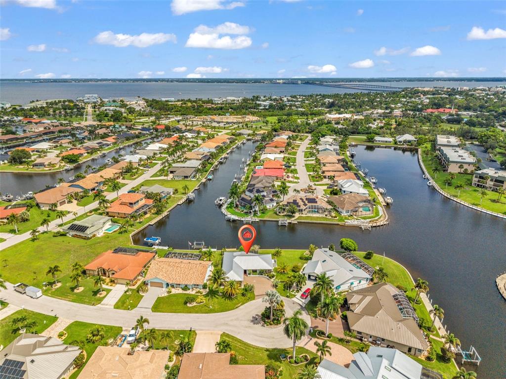 An aerial view shows a waterfront house with a red location pin on a cul-de-sac — 704 BIMINI LANE, PUNTA GORDA, FL