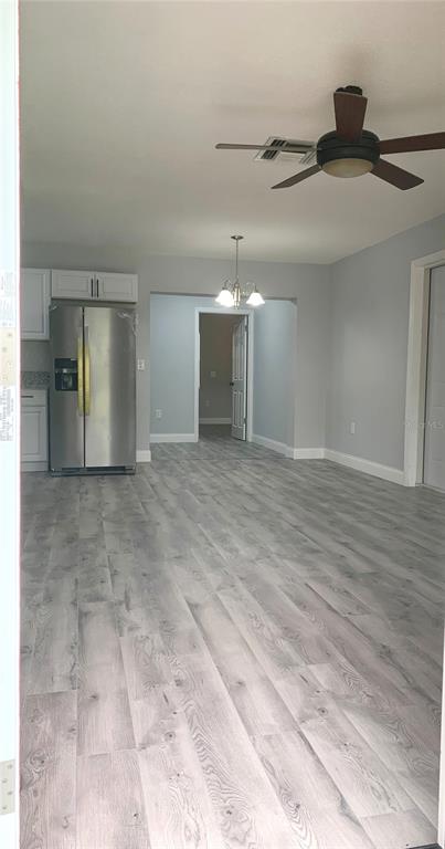 A room with light wood-look flooring, a stainless steel refrigerator, and a ceiling fan — 810 SWISS LANE, ORLANDO, FL
