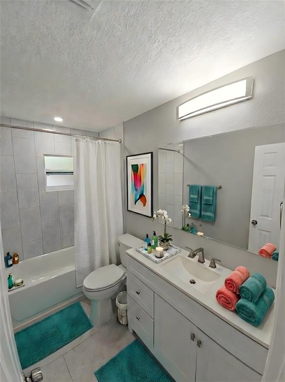 A bathroom features a white vanity, a bathtub with a shower, and teal accents — 2941 SHORE DRIVE UNIT A, SAFETY HARBOR, FL