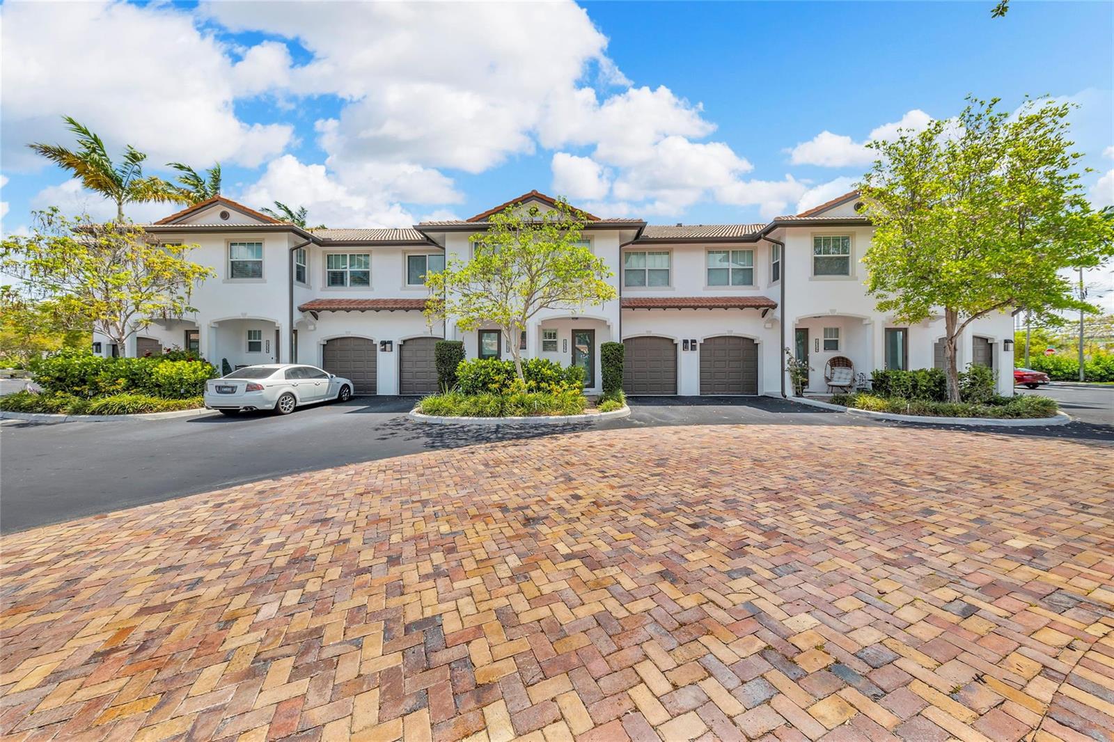 A multi-unit residential building with white stucco walls, brown garage doors, and a brick driveway — 1327 SE 3rd Avenue, Pompano Beach FL 33060, POMPANO BEACH, FL