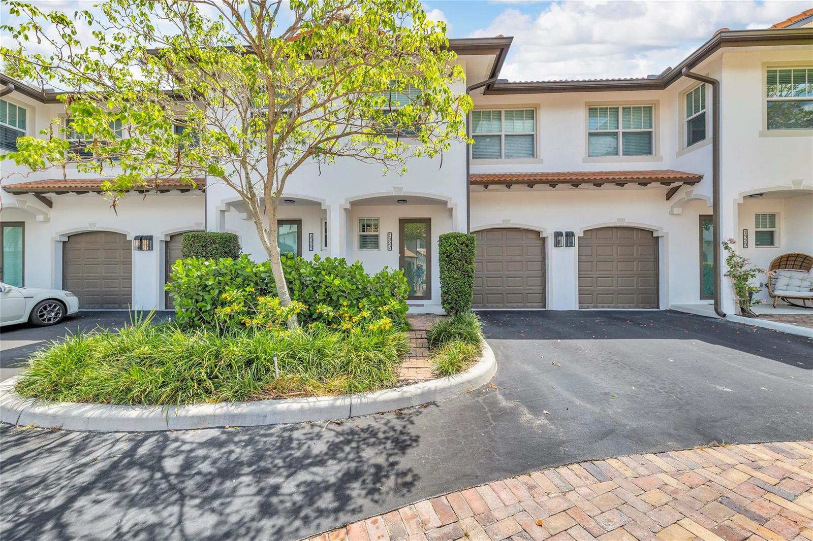 A row of two-story townhomes with brown garage doors and a central landscaped garden area — 1327 SE 3rd Avenue, Pompano Beach FL 33060, POMPANO BEACH, FL