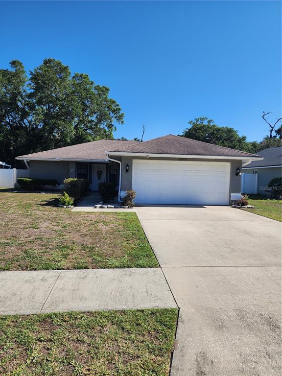 A single-story house with a white garage door, a concrete driveway, and a front lawn — 2814 WILDER PARK DRIVE, PLANT CITY, FL