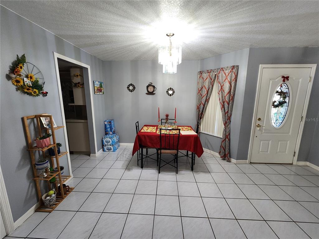 A dining room with white tile floors, a red-clothed table, and a chandelier — 2814 WILDER PARK DRIVE, PLANT CITY, FL