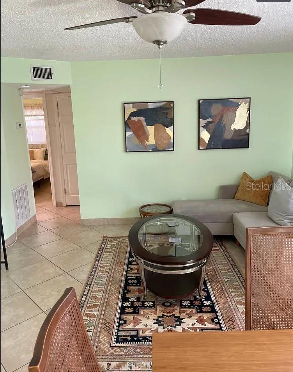 A living room features light green walls, a ceiling fan, a sectional sofa, and area rug — 641 FOLSOM STREET S, ST PETERSBURG, FL