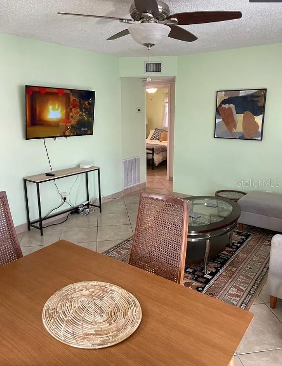A living room features light green walls, a ceiling fan, a television, and dining furniture — 641 FOLSOM STREET S, ST PETERSBURG, FL