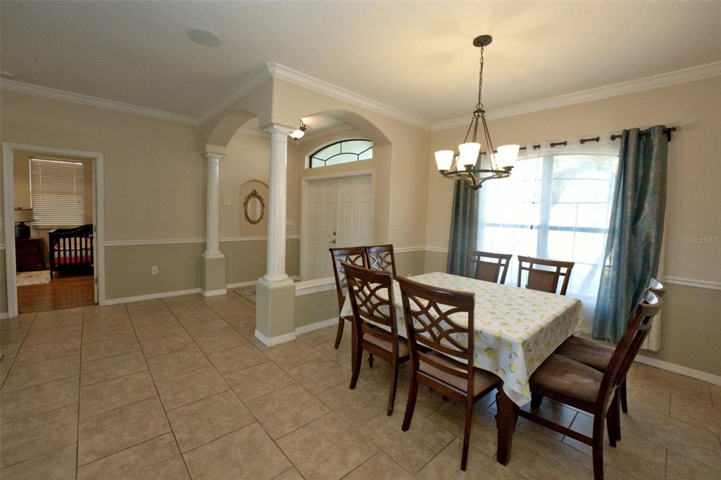 A dining room with tile flooring, a chandelier, and a table set for six — 3522 RENAULT CIRCLE, NORTH PORT, FL
