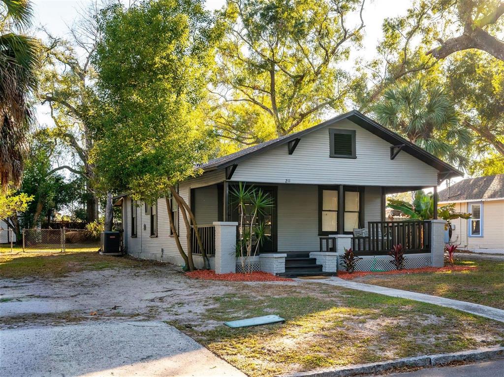 A single-story house with gray siding, a front porch, and a gabled roof — 211 E CLUSTER AVENUE, TAMPA, FL