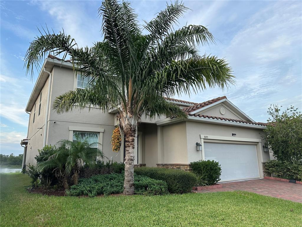 A two-story house with a palm tree in the front yard and a garage — 2093 LAKE SIDE AVENUE, DAVENPORT, FL