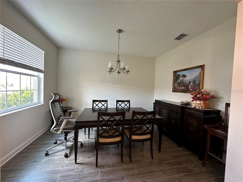 A dining room features a dark wood table, matching chairs, a sideboard, and tile flooring — 2093 LAKE SIDE AVENUE, DAVENPORT, FL