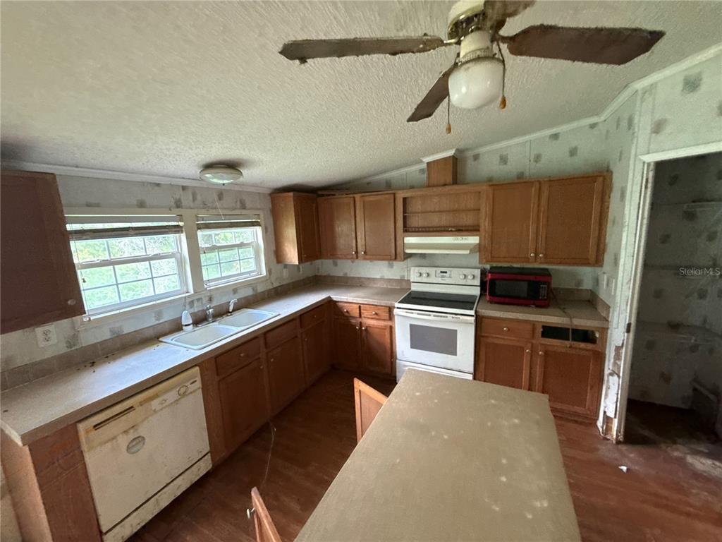 A kitchen with wooden cabinets, a white stove, a dishwasher, and a ceiling fan — 11410 ROCKRIDGE ROAD, LAKELAND, FL