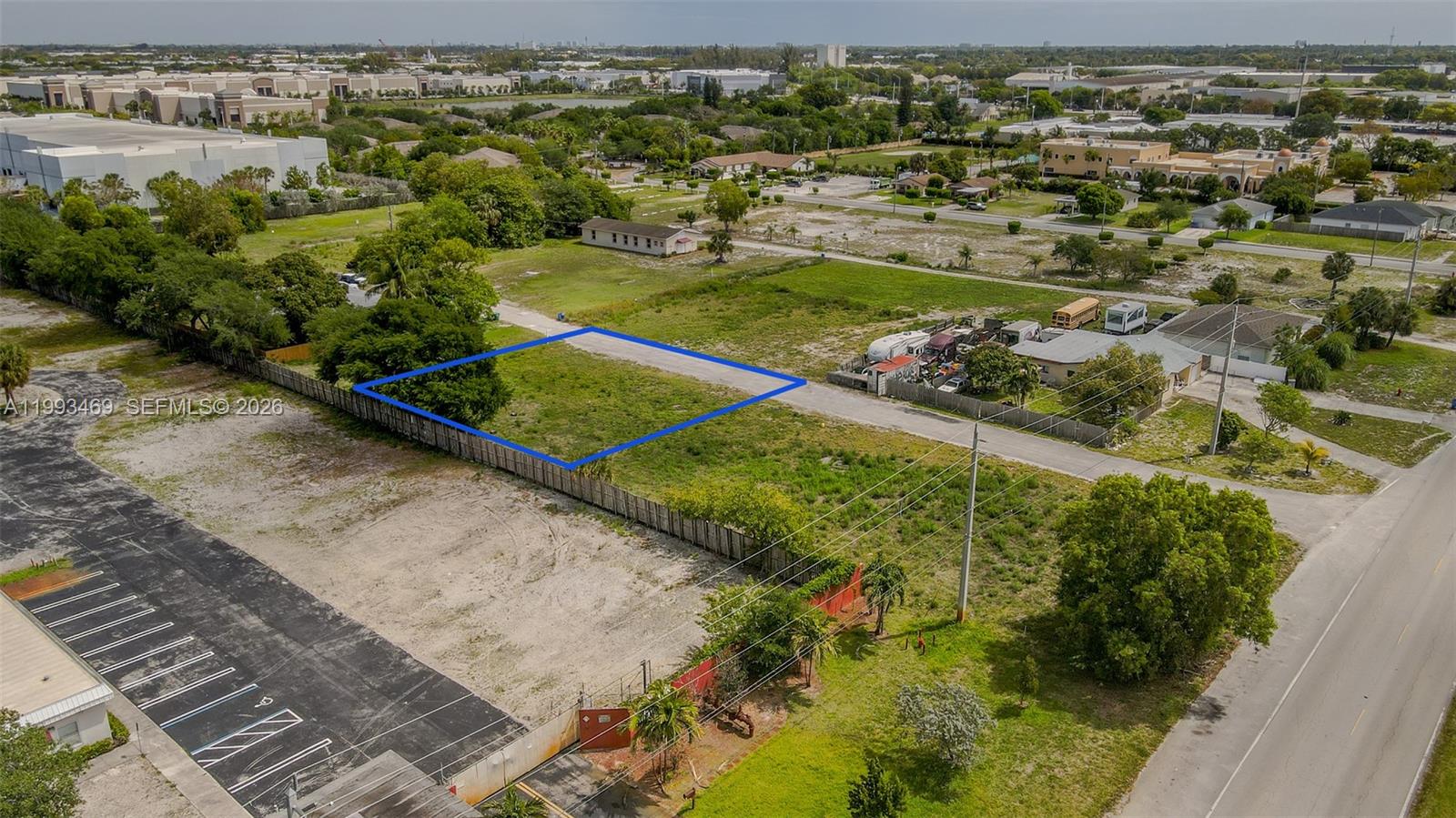 An aerial view shows a vacant rectangular lot outlined in blue next to a road — NW 19th Ave, Pompano Beach FL 33069, POMPANO BEACH, FL