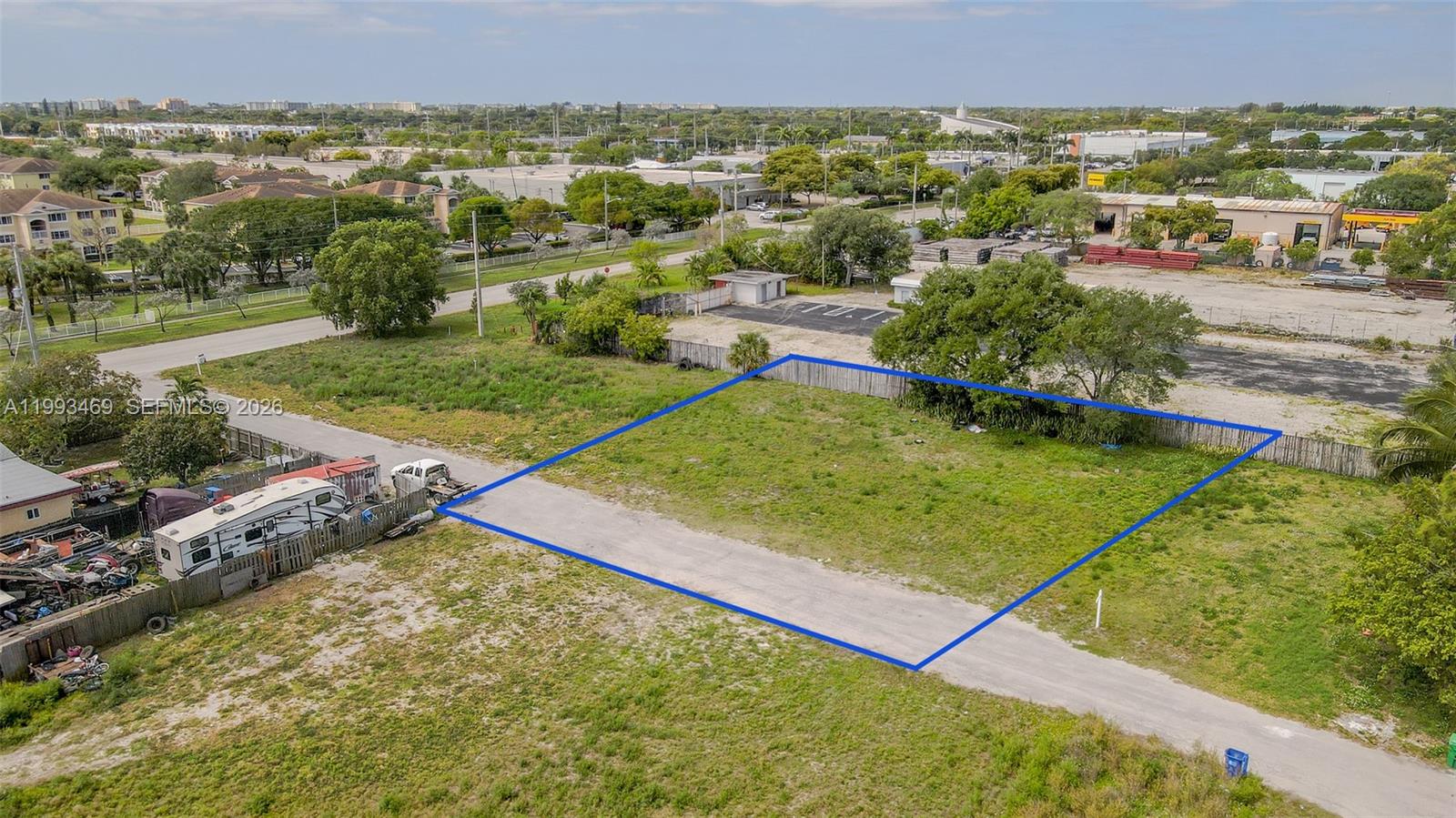 An aerial view shows a rectangular, vacant grass lot outlined in blue — NW 19th Ave, Pompano Beach FL 33069, POMPANO BEACH, FL
