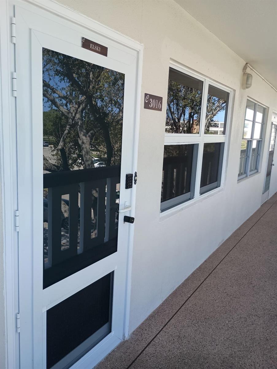 A white exterior door with a keypad lock and a windowed wall of a building — 3016 Ashby C # 3016, Deerfield Beach FL 33442, DEERFIELD BEACH, FL