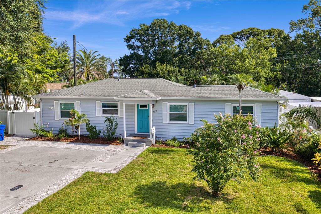 A light blue single-story house with a teal front door and a paved driveway — 417 HAMPTON AVENUE NE, ST PETERSBURG, FL