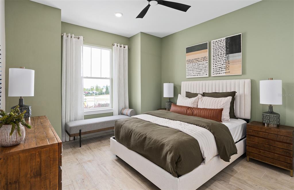 A bedroom features sage green walls, a tufted headboard, and a window with a bench — 6812 WILLOW BANK DRIVE, CLERMONT, FL