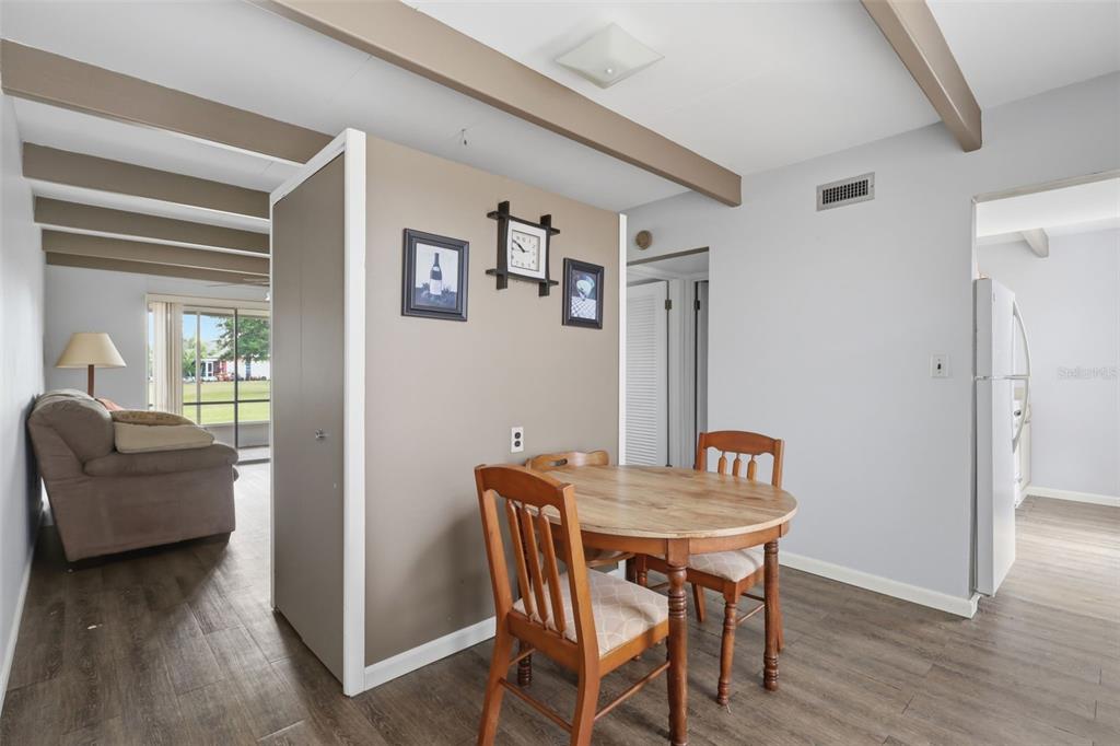 A dining area with a round wooden table sits adjacent to a living room space — 2607 CLUB CIRCLE UNIT 2607, LAKE WALES, FL